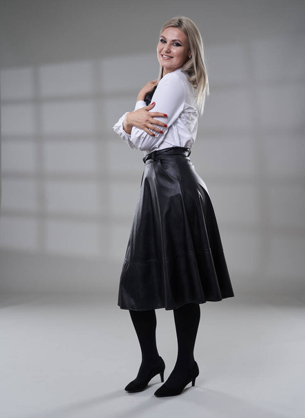 Business woman in black skirt and white shirt, full length studio portrait on gray background - Zdjęcie, obraz