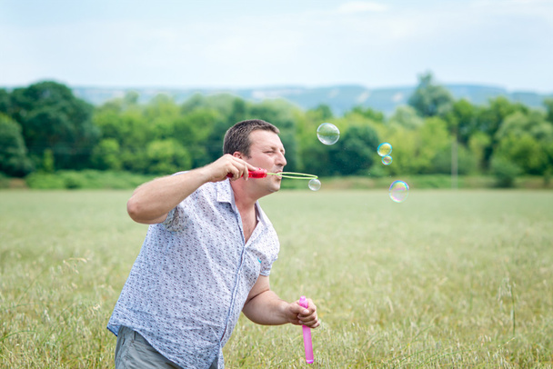 young man playing with soap bubbles - Foto, afbeelding