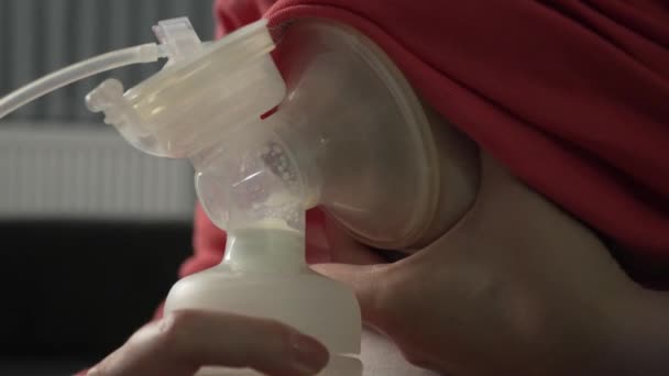 Close-up op het midden van onbekende blanke vrouw houden en gebruiken baby fles en borstpomp pompen melk voor haar baby en lactatie thuis 's nachts - ouderschap en moederschap concept - Video