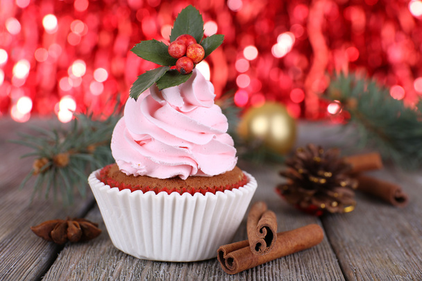Cup-cake with cream and Christmas decoration on wooden table and shine brightly background - 写真・画像