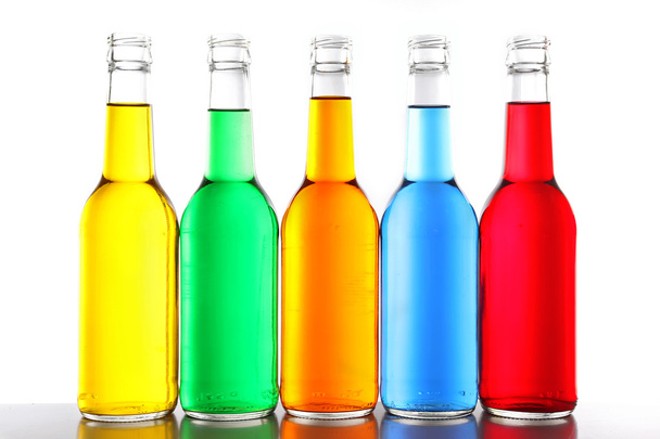 Colorful alcoholic beverages in glass bottles isolated on white - Valokuva, kuva
