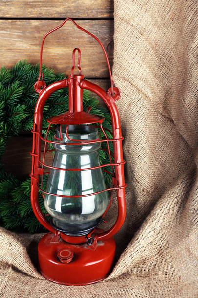 Kerosene lamp with wreath on wooden planks background - Foto, imagen