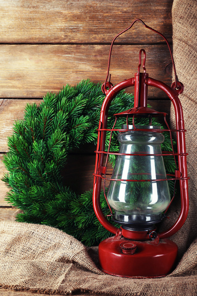 Kerosene lamp with wreath on wooden planks background - Foto, Imagen