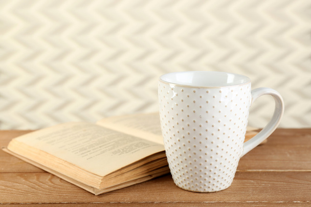 Cup of tea and book on table, on light background - Φωτογραφία, εικόνα