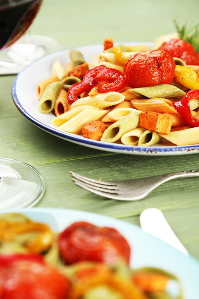 Pasta salad with pepper, carrot and tomatoes on wooden table background - Foto, Imagen