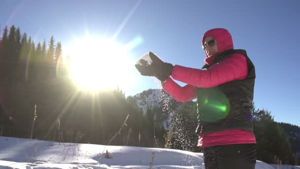 Girl slowly pours snow from hands - Filmati, video