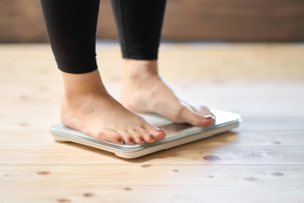 Los pies de una mujer asiática en una escala de peso - Foto, Imagen