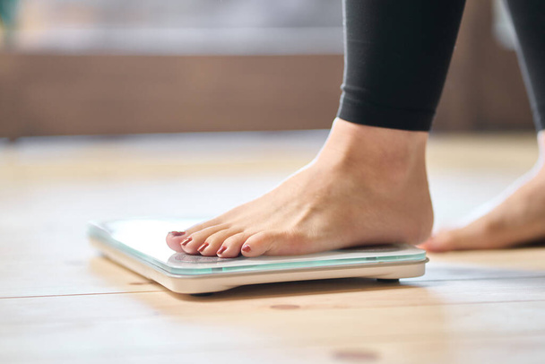 Feet of an Asian woman on a weight scale - Foto, Bild