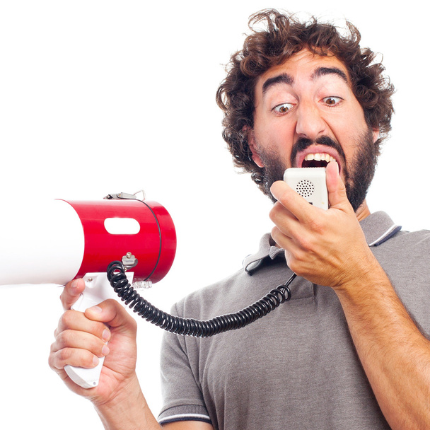 Young crazy man shouting with a megaphone - Фото, изображение