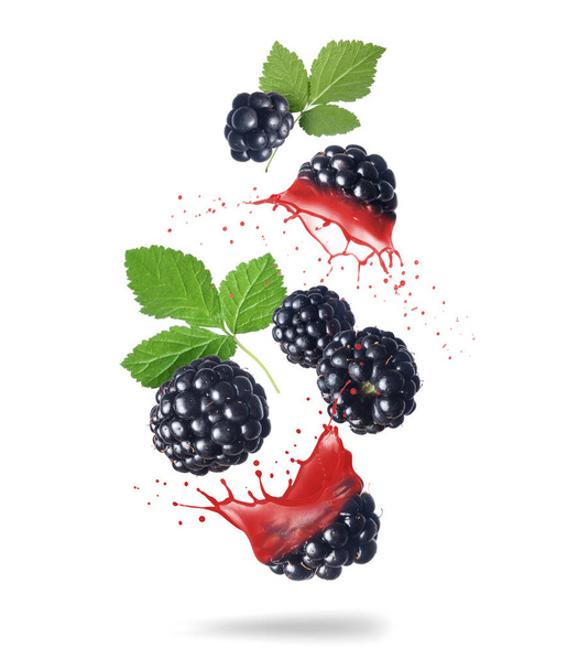 Whole and sliced blackberries with juice splashes in the air isolated on a white background - Fotoğraf, Görsel