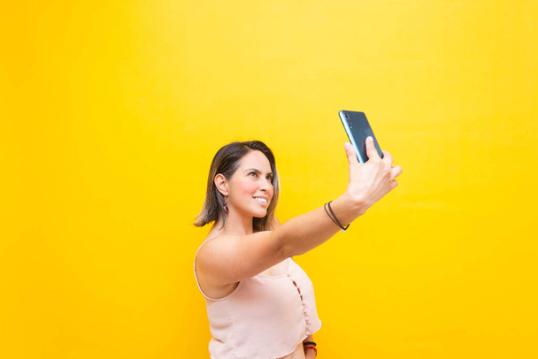 середнього віку іспаномовна жінка в 40-х робить відеодзвінок на мобільний телефон
 - Фото, зображення