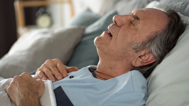 Alter Mann schläft im Bett mit offenem Mund - Foto, Bild