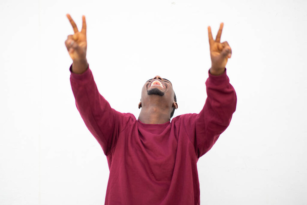 Portret van vrolijke jonge Afrikaanse man glimlachend met handvredestekens op witte achtergrond - Foto, afbeelding