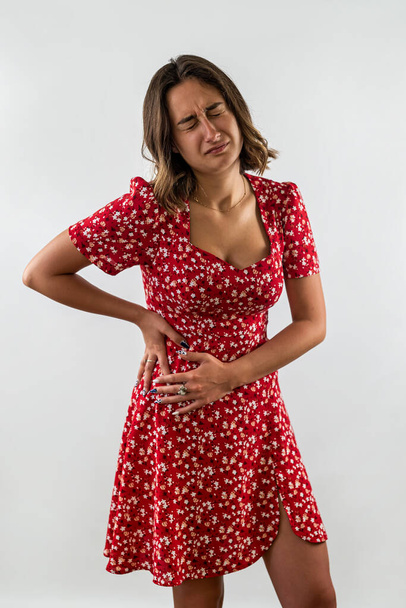 Overstuur meisje voelt keelpijn in de schildklier griep of osteochondrose. Verstoorde zieke vrouw op witte studio achtergrond - Foto, afbeelding