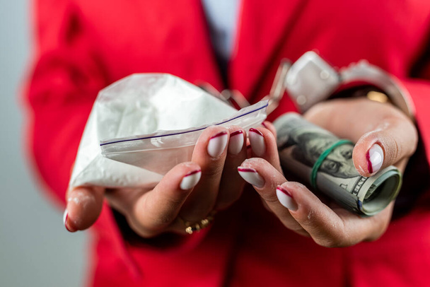 woman whose hands are handcuffed with money and drugs. Concept of punishment for possession and distribution and use of narcotic drugs. Concept of drugs. - Foto, imagen