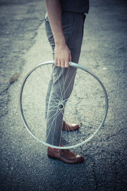 Homem segurando roda de bicicleta velha
 - Foto, Imagem