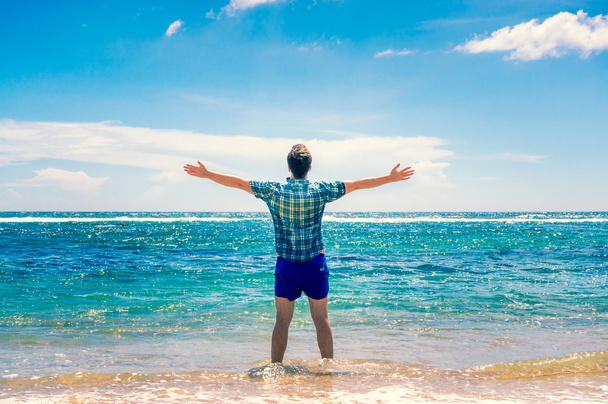 Man enjoying freedom  in water on the beach - Foto, afbeelding