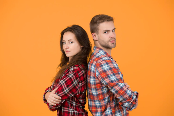 Adult siblings. Sister and brother. Confident team. Back to back standing man and woman. Fashion clothes shop. Modern couple. Couple checkered shirts. Family look. People concept. Family relations. - Zdjęcie, obraz