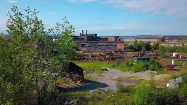 Een ontwikkelende provincie. Clip.Drone uitzicht op bouwplaatsen gelegen in de buurt van fabrieken tegen de achtergrond van een felle stralende zon. Hoge kwaliteit 4k beeldmateriaal - Video