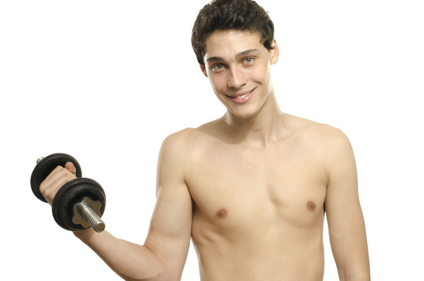 Skinny man training his bicep muscle. Beautiful teenager lifting a dumbbell.Anorexic young man training to become stronger - Foto, immagini