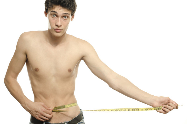 Skinny young man posing fashion with a centimeter, anorexic look. Slim body - Foto, Imagem