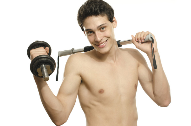 Skinny man training his bicep muscle. Beautiful teenager lifting a dumbbell.Anorexic young man training to become stronger, flexing a bendy bar - Photo, Image