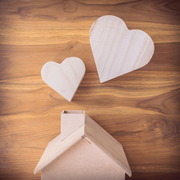 ξύλινο σπίτι και η καρδιά για καφέ φόντο ξύλου - Φωτογραφία, εικόνα