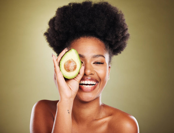 Avocado skincare, black woman and beauty, natural wellness, cosmetics and facial treatment, healthy diet and detox on studio background. Portrait of happy young model, organic food and dermatology. - Photo, image