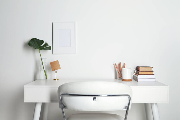 Komfortabler Arbeitsplatz mit weißem Schreibtisch in der Nähe der Hauswand - Foto, Bild