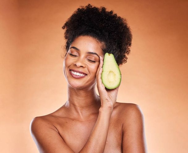 Skincare, wellness and black woman with avocado in studio on brown background for body care. Beauty, spa and female with vegetable for organic, natural and healthy beauty products and cosmetics. - Fotografie, Obrázek