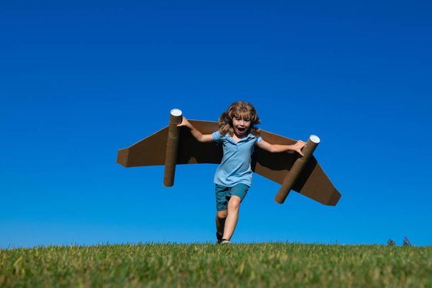 Criança feliz brincando com jetpack de brinquedo. Kid piloto se divertindo ao ar livre. Sucesso criança, inovação e líder. Criativa e conceito de arranque - Foto, Imagem