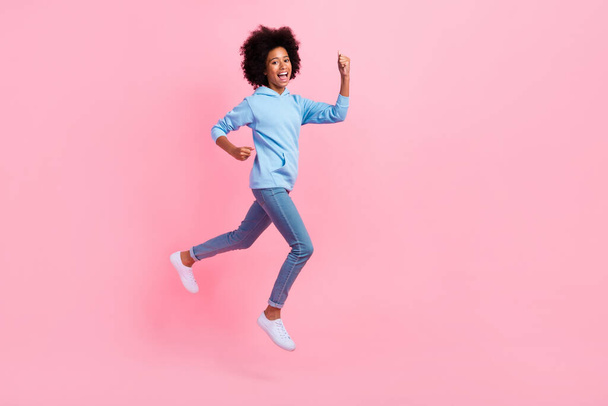 Full length profile portrait of delighted astonished person jumping raise fists isolated on pink color background. - Фото, изображение