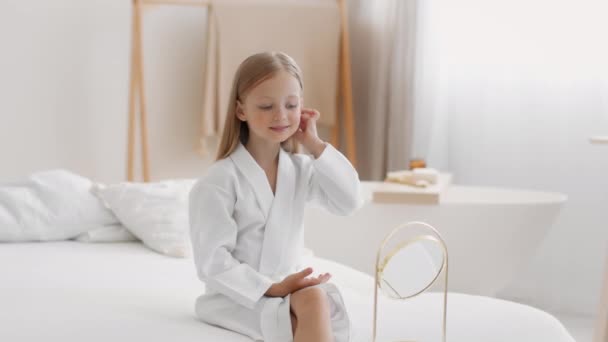 Little lady. Cute girl wearing bathrobe looking at mirror and fixing her hairstyle, playing like her mother at home, slow motion, free space - Footage, Video