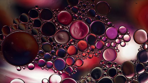 Абстрактная красочная пищевая масляная капает пузыри и сферы, текущие на поверхности воды Макрофотография - Фото, изображение