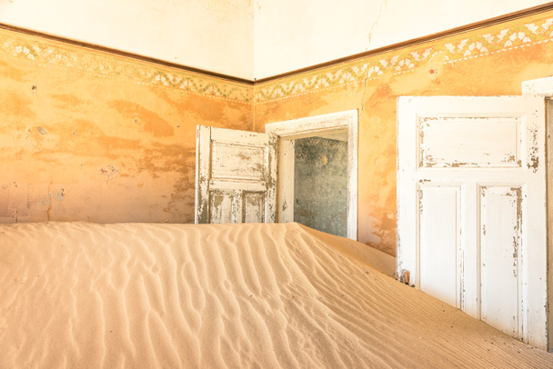 Abandoned house full of sand from the desert in the ghost town of Kolmanskop - Sightseeing around Luderitz in Namibia - African wonders and mysteries - Photo, Image
