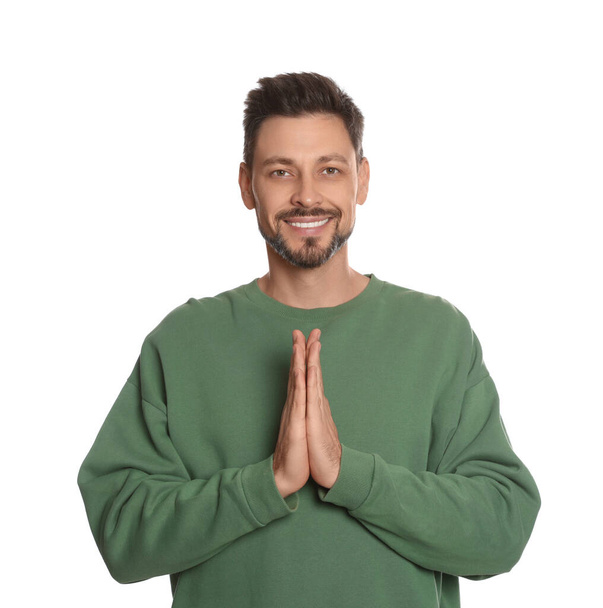 Man with clasped hands praying on white background - Foto, Imagen