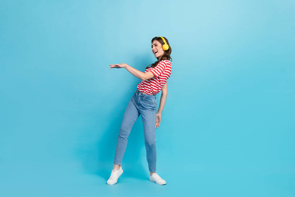 Full length photo of cute funny girl dressed red t-shirt earphones dancing having fun isolated blue color background. - Foto, afbeelding
