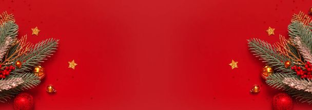 Украшение елки и сосны на красном фоне с копировальным пространством. Новогодняя открытка. Плоский лежал. - Фото, изображение