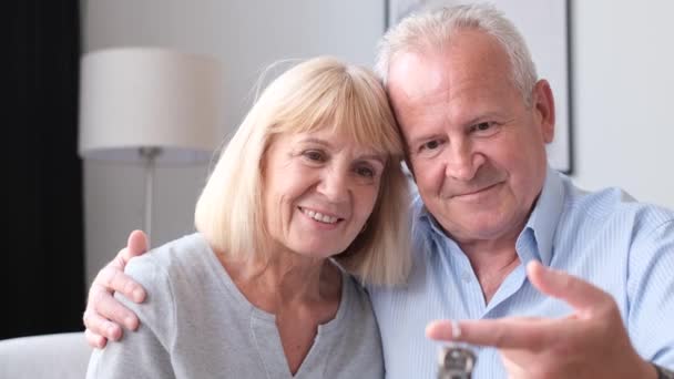 Двоє щасливих літніх людей купують новий будинок, який тримає ключі в руках. Купівля власного будинку
 - Кадри, відео