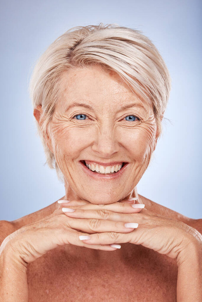 Ihonhoito, hyvinvointi ja muotokuva vanhempi nainen hymyillen sinisellä taustalla studiossa. Kauneus, meikki ja kasvot vanha nainen luonnollinen iho aiheuttaa ihotautioppi, kehon hoito ja antiaging kosmetiikka. - Valokuva, kuva