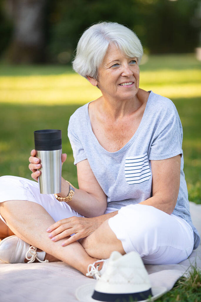 senior woman enjoying a warm drink outdoors - Fotografie, Obrázek