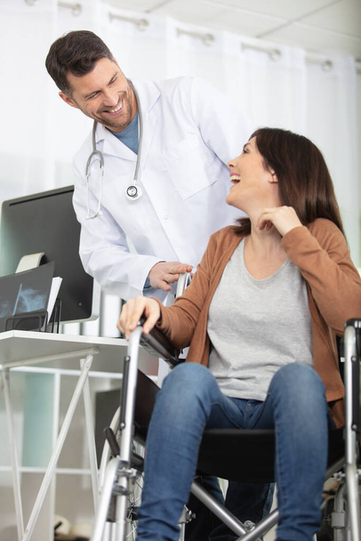 doctor talking to happy woman in wheelchair - Photo, Image