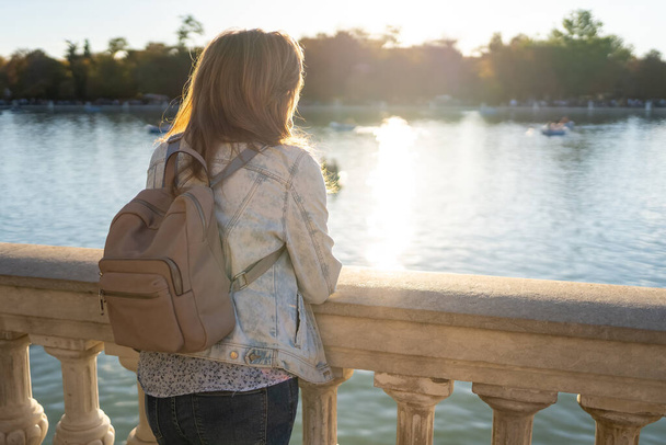 Woman leaning out of a large freshwater lake in Madrids Retiro Park - Foto, Bild