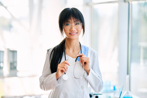 Smiling female asian doctor witn stethoscope wearing in lab coat looking to camera. Health care, medicine concept - Foto, afbeelding