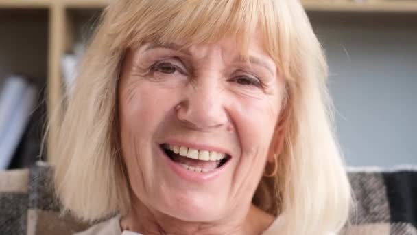 Egy idős kaukázusi nő portréja, amint nevet, miközben a kamerába néz. A boldog nyugdíjas örül, a nagymamának pozitív érzelmei vannak - Felvétel, videó