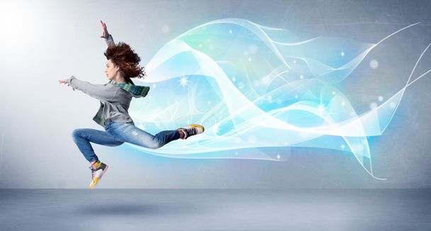 Cute teenager jumping with abstract blue scarf around her - Zdjęcie, obraz