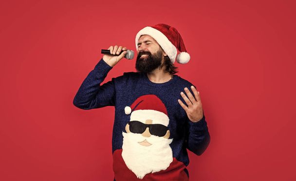 present and gift shopping sale. happy new year. merry christmas. cheerful bearded man in santa claus hat and sweater. brutal hipster celebrate xmas party. winter holiday preparations. - Fotografie, Obrázek
