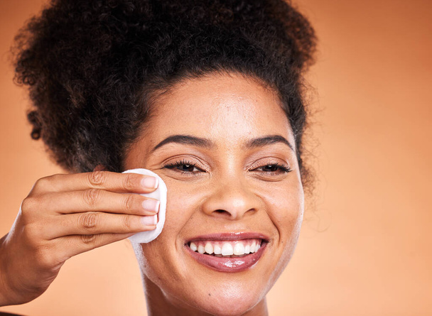 Face, skincare and black woman with cotton pad on orange studio background mockup. Happy, health and female model with product for cleaning facial makeup, cosmetics or beauty products with mock up. - Фото, зображення
