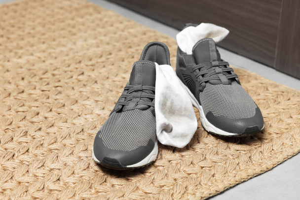 Sneakers with dirty socks on woven mat indoors, closeup. Space for text - Zdjęcie, obraz