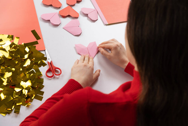 Fazendo corações de origami para Dia dos Namorados. Artesanato feito de papel com suas próprias mãos - Foto, Imagem